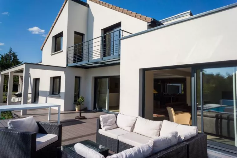 Installation de baies vitrées dans un salon qui donne sur une grande terrasse aménagée à Verfeil, Verfeil, Fenêtres & Cie